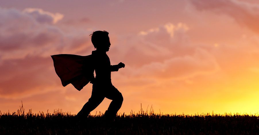 Boy Plays Super Hero At Sunset.