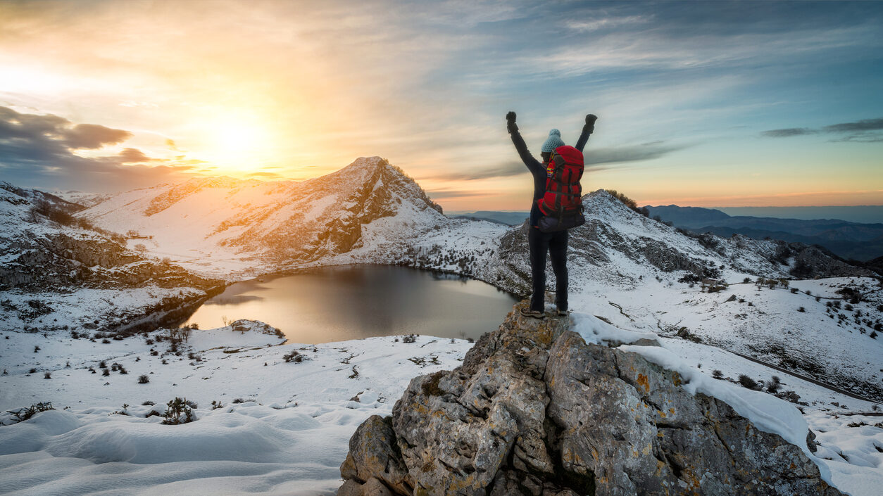 Hiker Woman Rising Arms In Victory Sign On Snowy Mountain