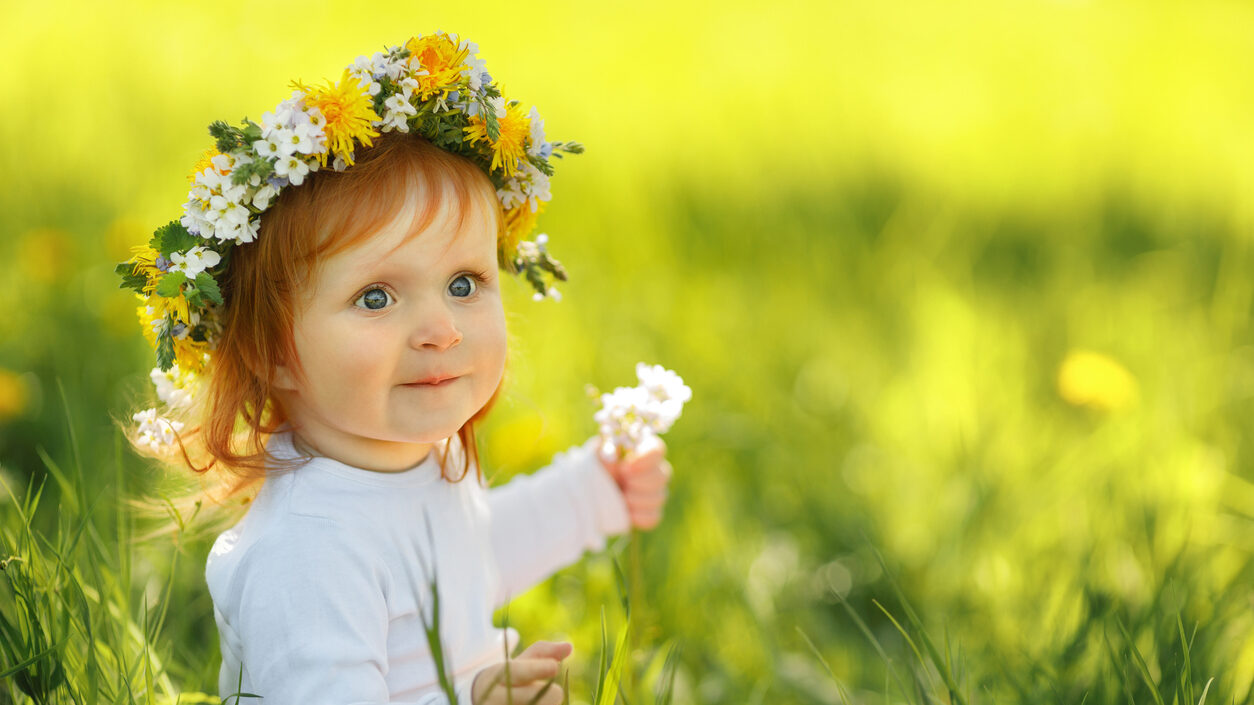 Cute Little Girl Is Wearing Beautiful Spring Wreath Outdoors