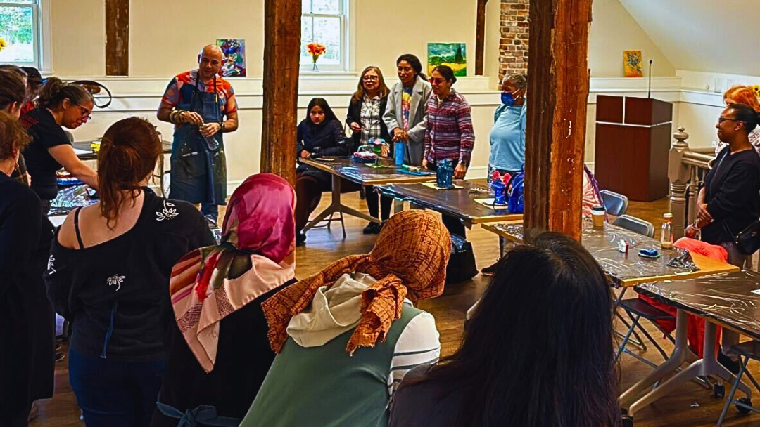 A sculpture class listening to the teacher